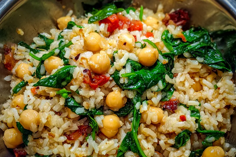A step-by-step cooking process of the Hearty Mediterranean Rice Bowl, showcasing sautéing, boiling, and mixing ingredients.