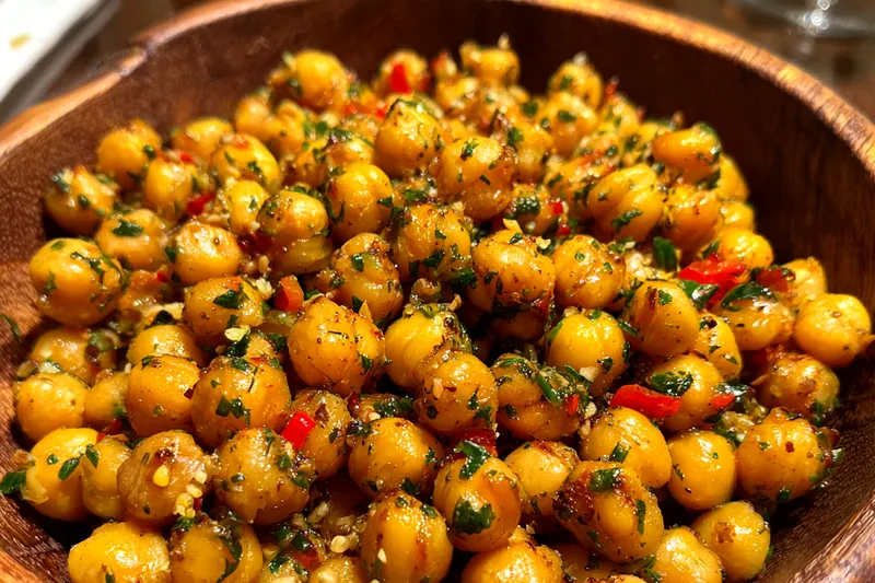 A close-up of Herb-Infused Roasted Chickpeas cooling on a baking sheet.