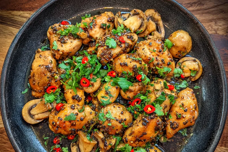 A colorful array of fresh ingredients for Spicy Black Pepper Chicken, including chicken, spices, and vegetables.